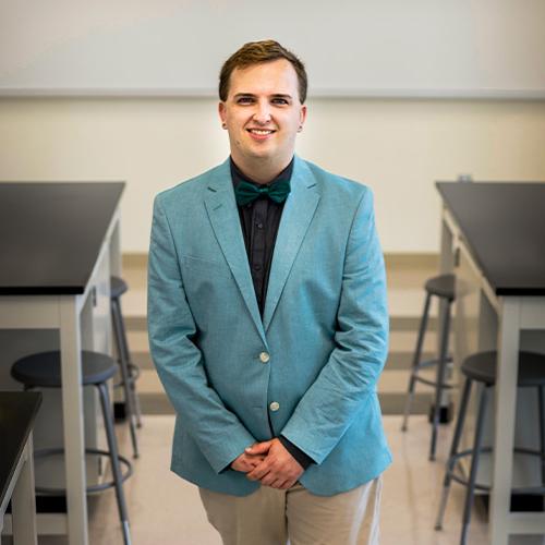 Austin Greitz posing for an image in a classroom